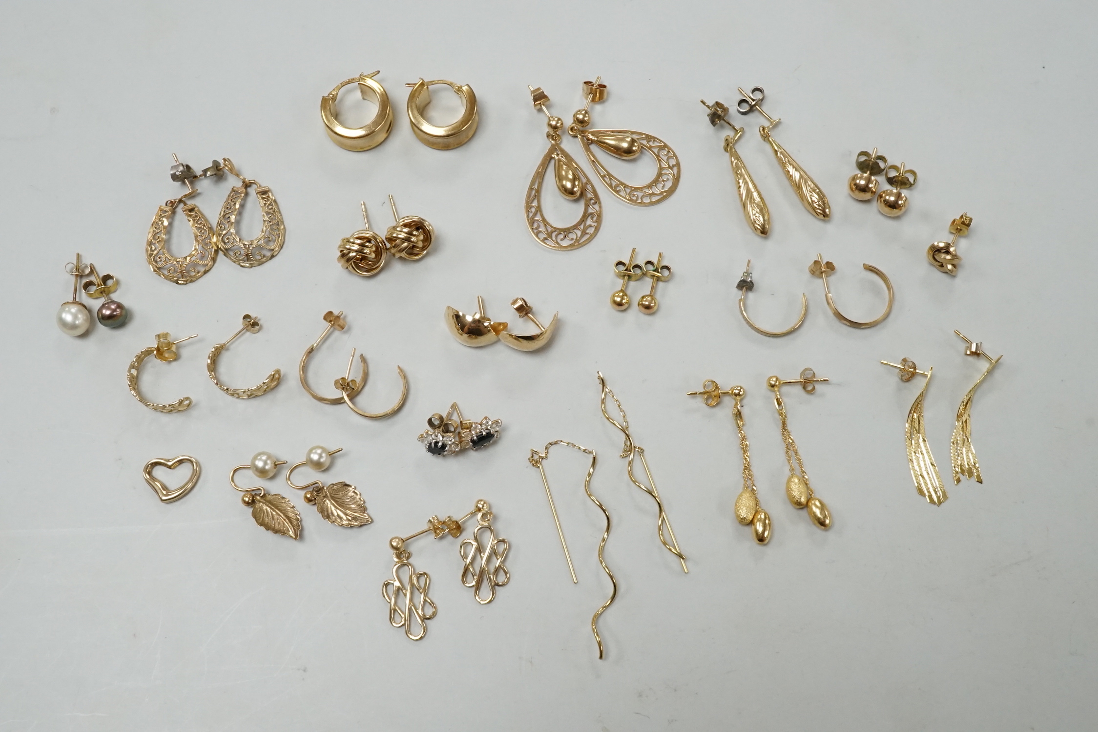 Seven assorted modern pairs of 9ct earrings including tassel drop and pear shaped, 12.7 grams and ten other yellow metal pairs, three odd ear studs and a small heart pendant?